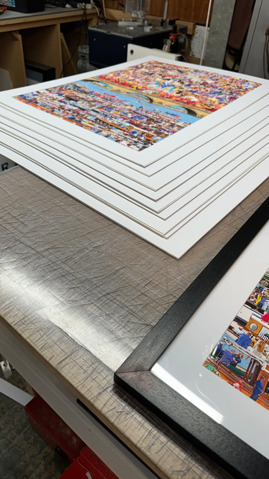 A collection of framed limited edition giclee prints displayed in a gallery